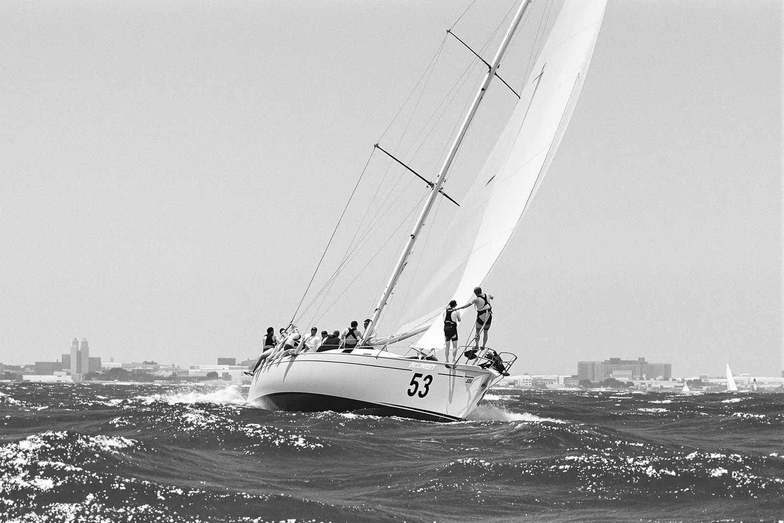 Velero de regata escorado con la tripulación colgada de la banda
